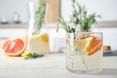 Photo of Refreshing grapefruit cocktail with rosemary on table