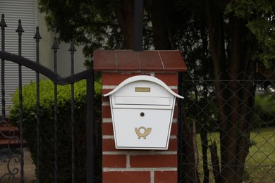 White metal letter box on fence outdoors