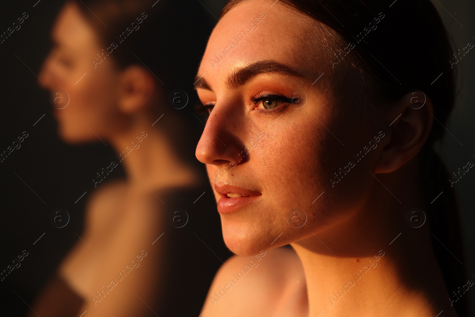 Photo of Fashionable portrait of beautiful woman with fake freckles on blurred background, closeup