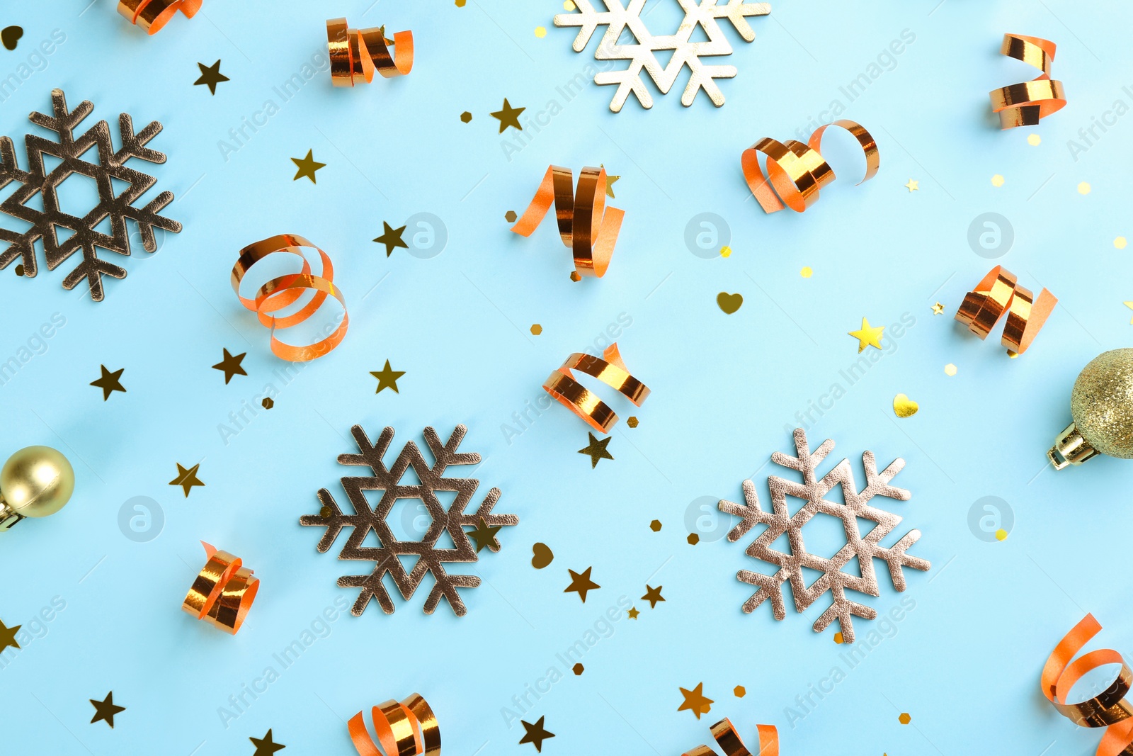 Photo of Flat lay composition with serpentine streamers and Christmas decor on light blue background