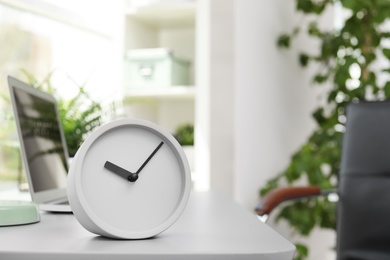 Photo of Analog alarm clock on table in office. Time to work