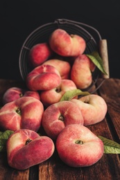 Photo of Fresh ripe donut peaches on wooden table, closeup