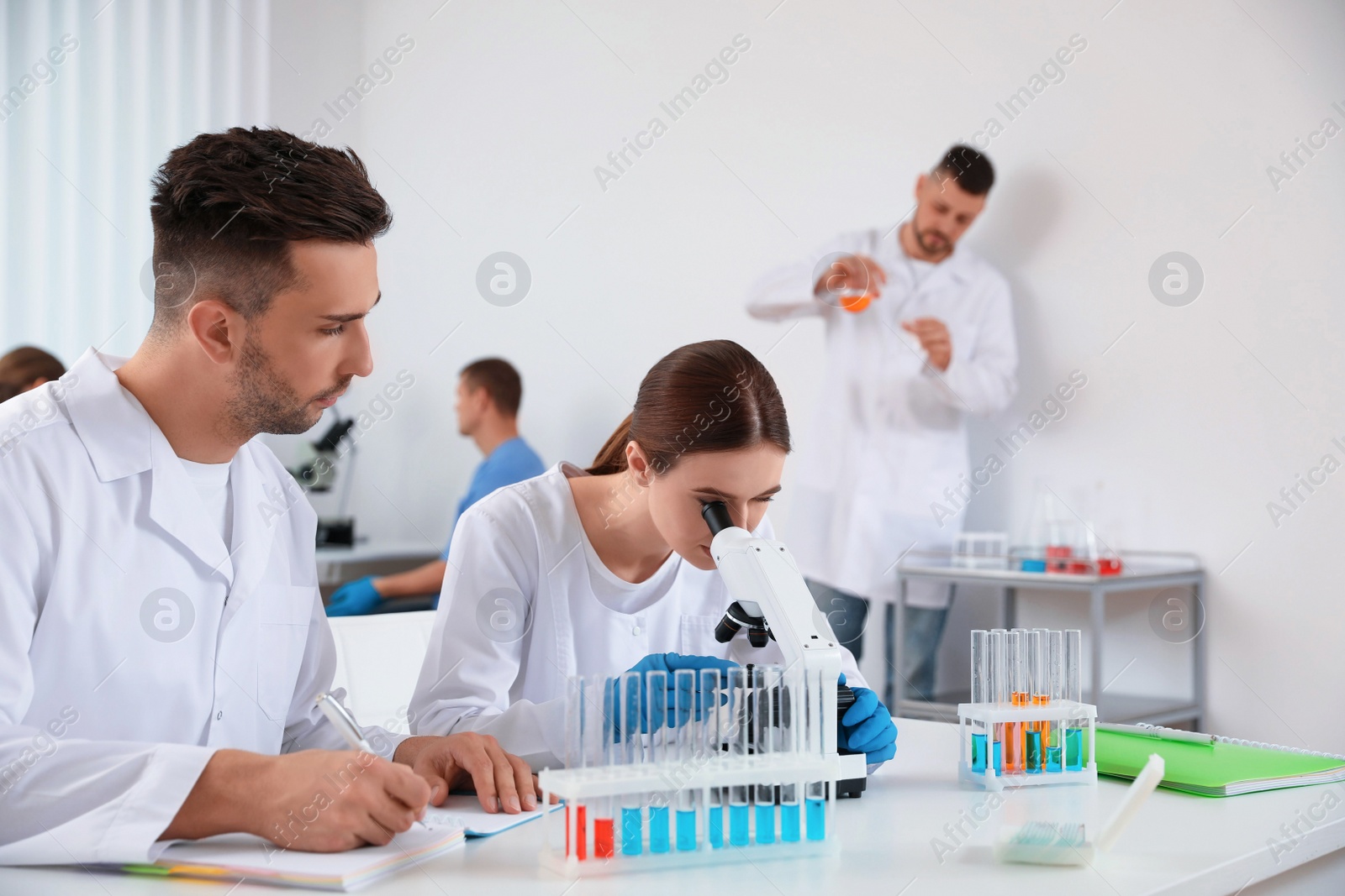 Photo of Medical students with microscope in modern laboratory