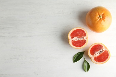 Fresh tasty grapefruits on wooden background, top view with space for text