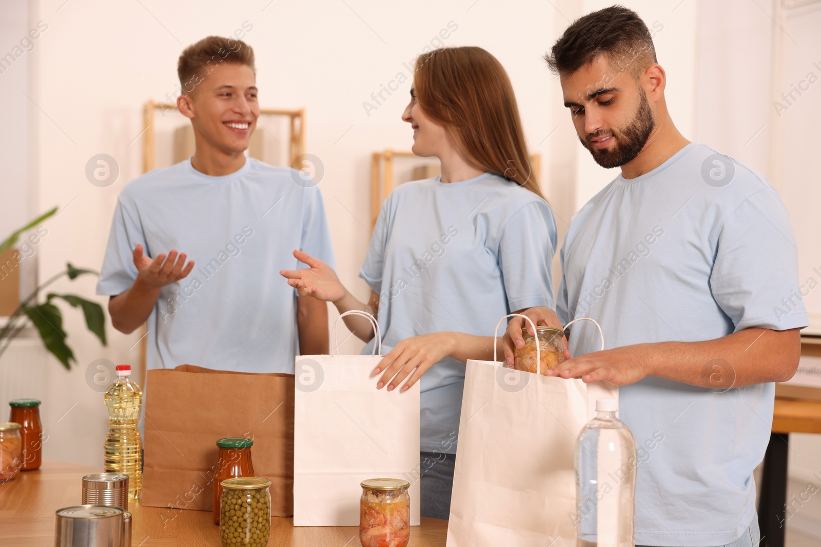 Photo of Group of volunteers packing food products indoors