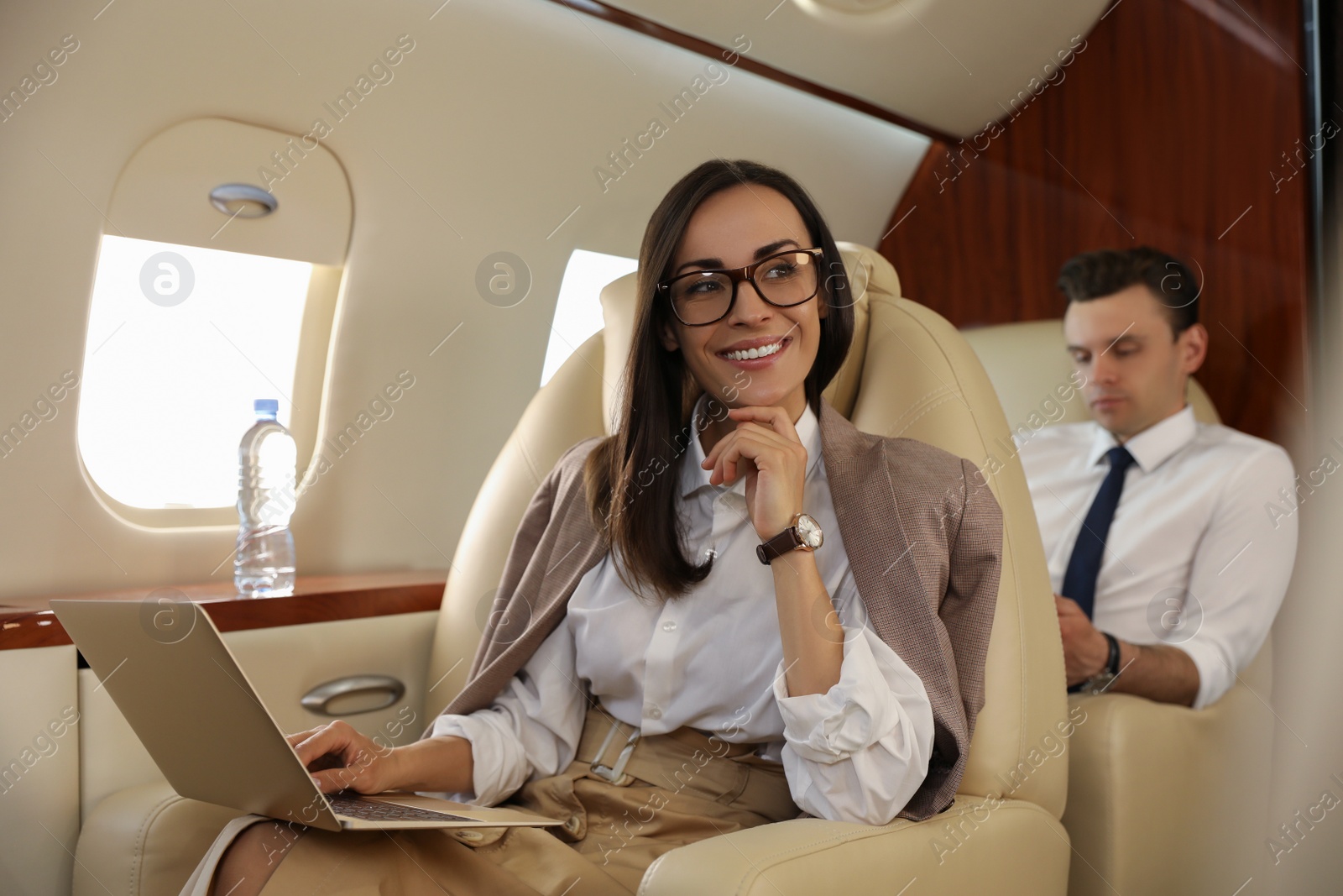 Photo of Businesswoman working on laptop in airplane during flight