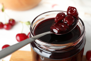 Photo of Jar of delicious pickled cherries, closeup view
