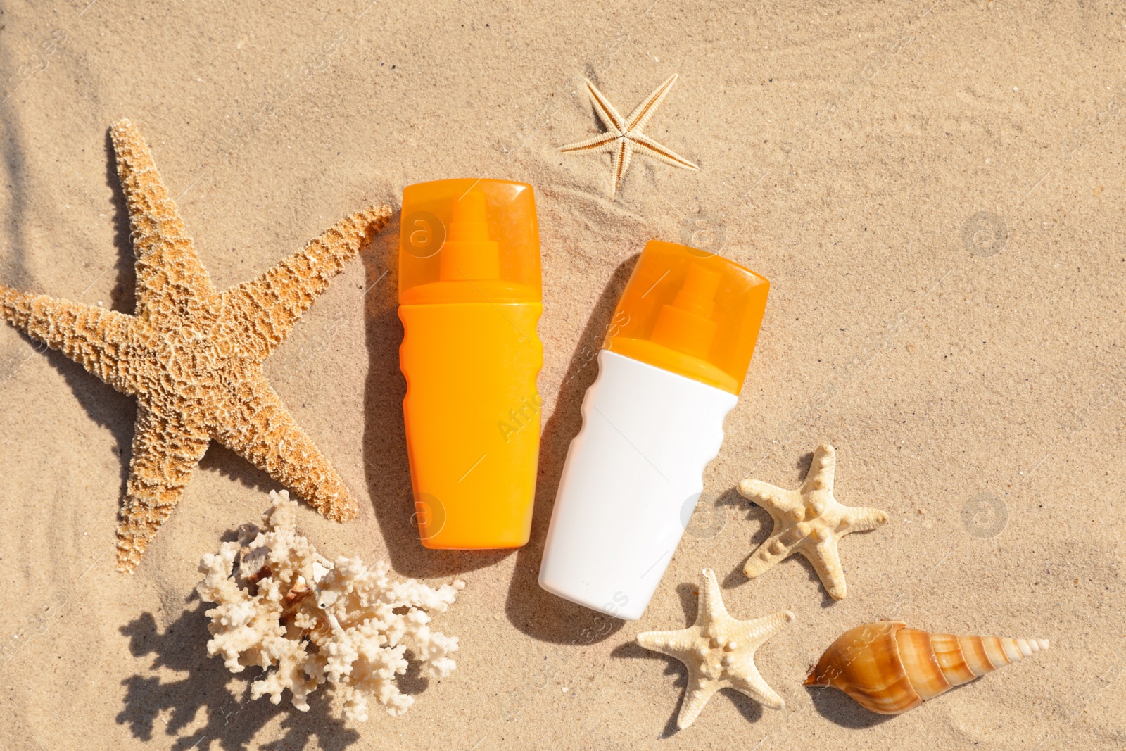 Photo of Flat lay composition with bottles of sunblock on sandy beach