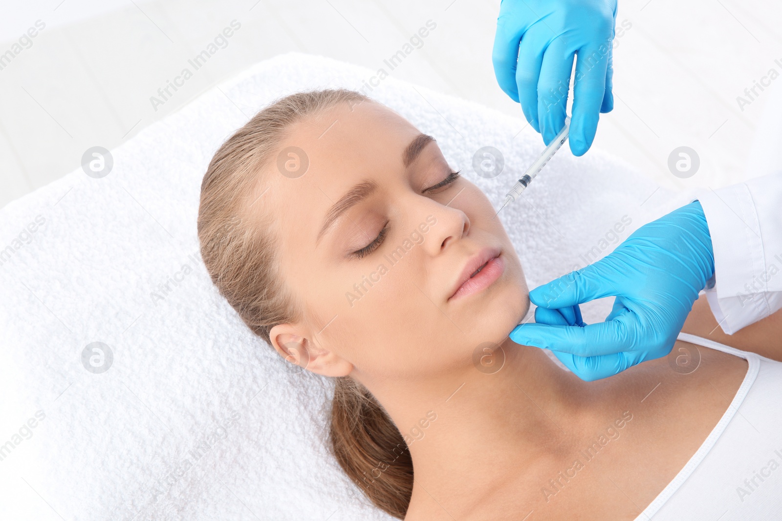 Photo of Young woman getting facial injection in clinic. Cosmetic surgery concept