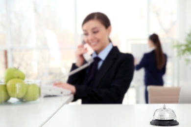 Service bell and female receptionist in hotel