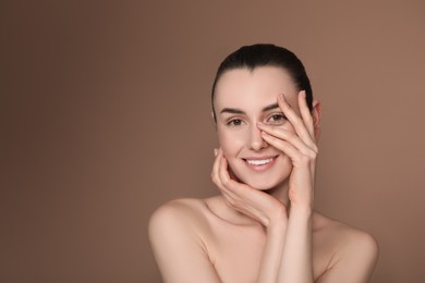 Portrait of beautiful young woman on brown background. Space for text