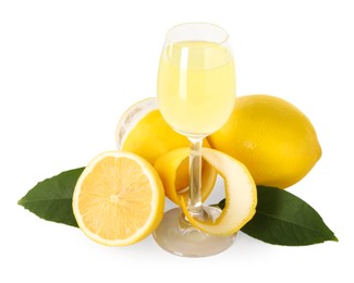 Photo of Liqueur glass with tasty limoncello, lemons and green leaves isolated on white