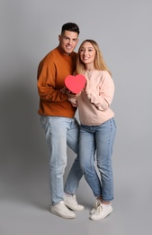 Lovely couple with decorative heart on grey  background. Valentine's day celebration