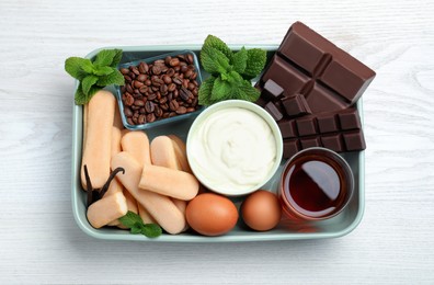 Baking dish with ingredients for tiramisu on white wooden table, top view