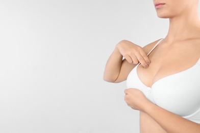 Photo of Woman checking her breast on white background, closeup. Space for text