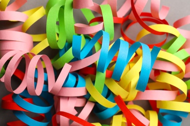 Colorful serpentine streamers on grey background, flat lay