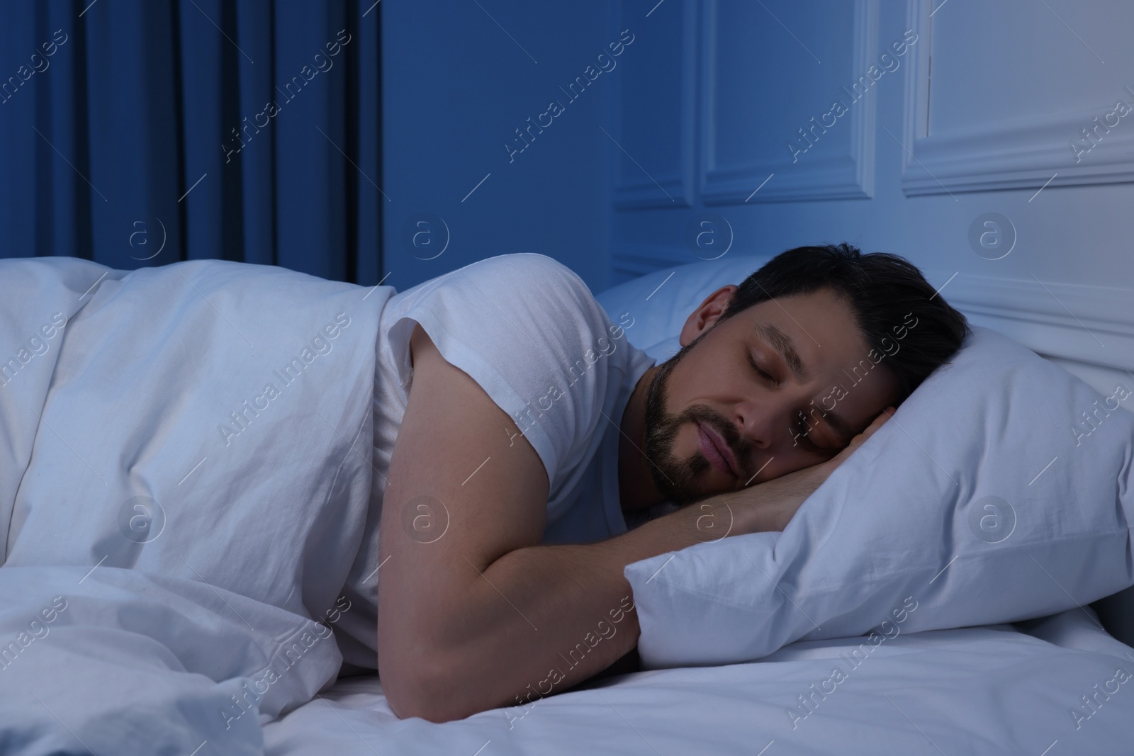 Photo of Handsome man sleeping in bed at night