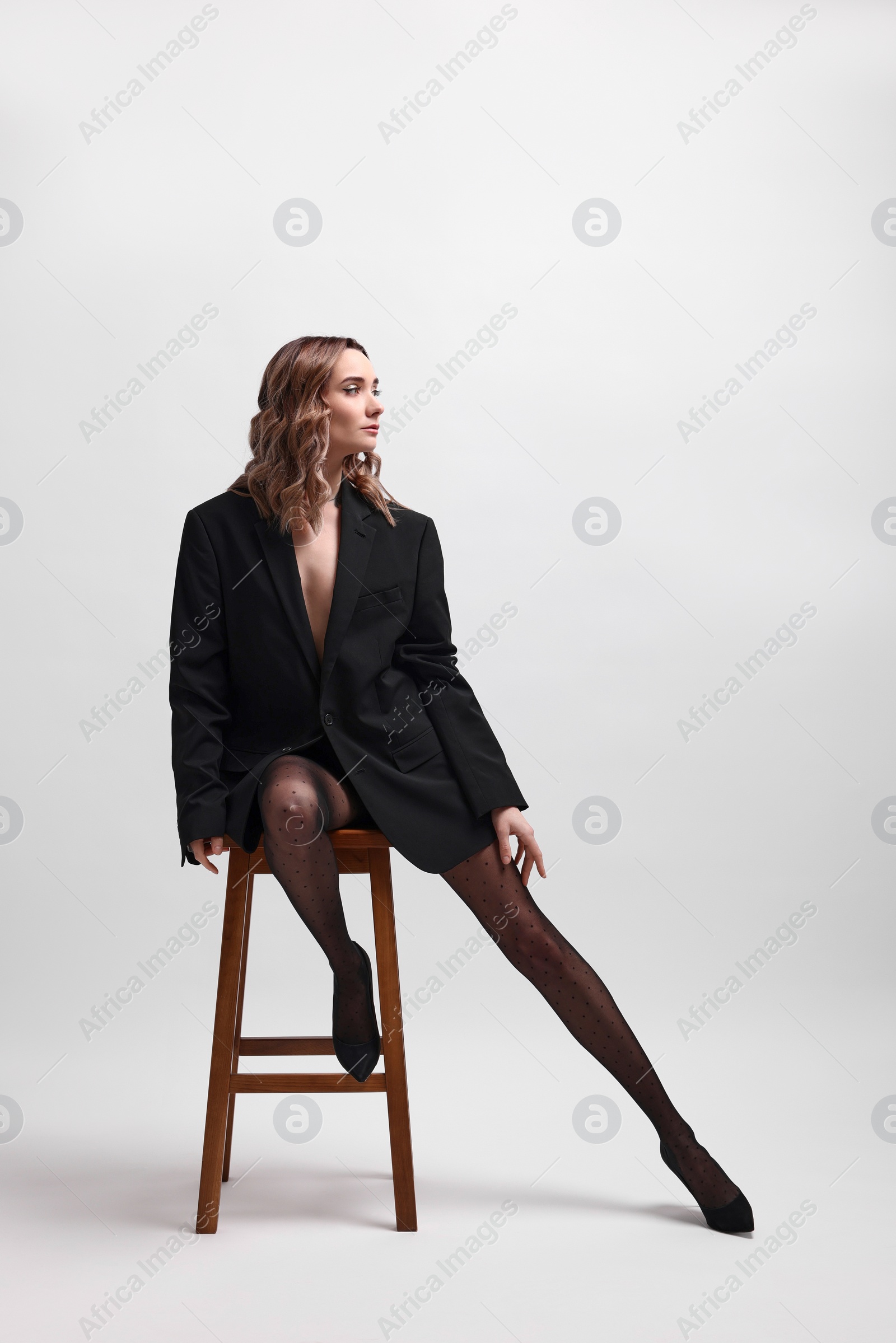 Photo of Beautiful woman in stylish black outfit posing on white background