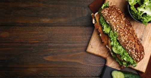 Image of Delicious sandwich with schnitzel on wooden table, top view. Banner design with space for text