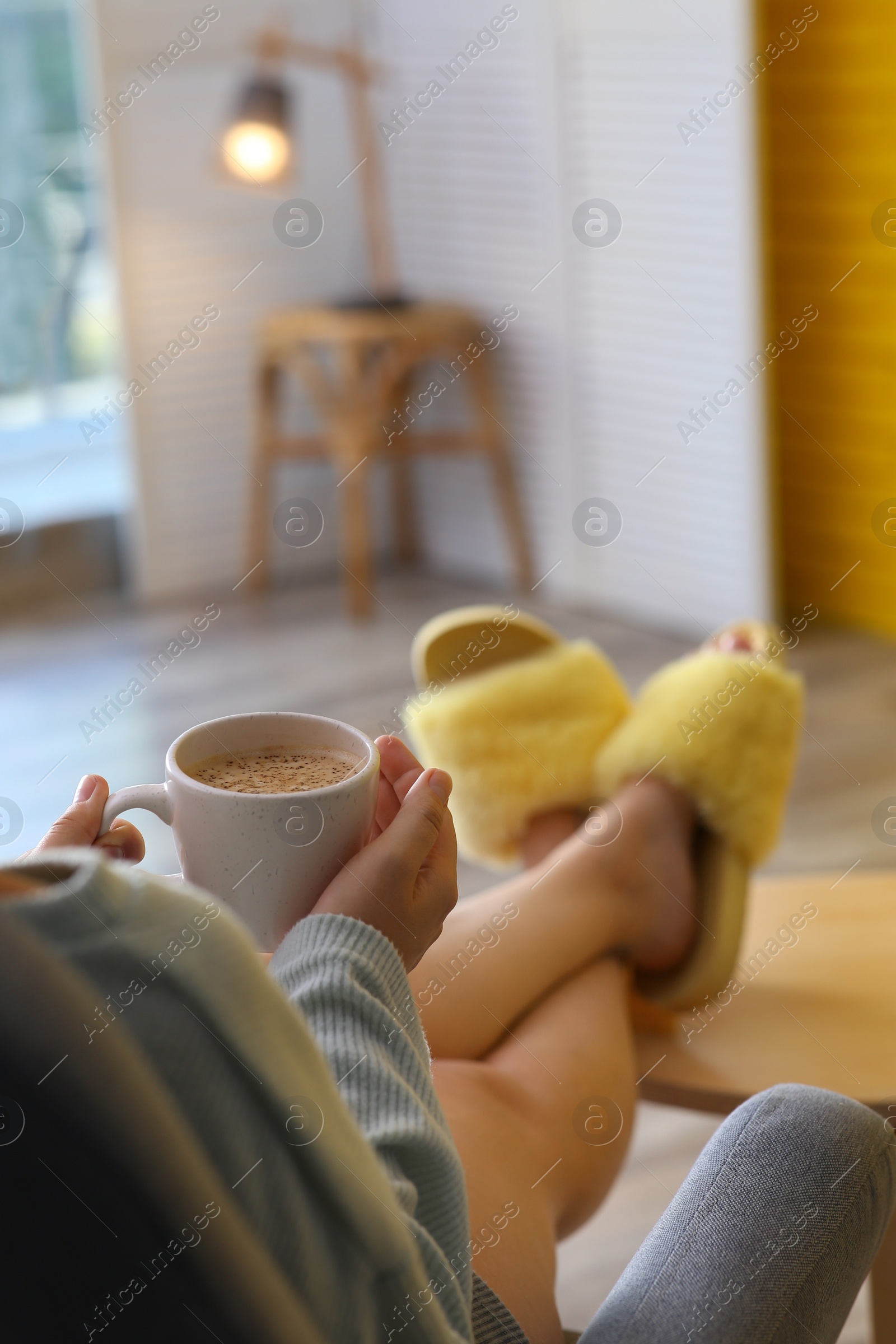 Photo of Woman with cup of aromatic coffee relaxing at home, closeup