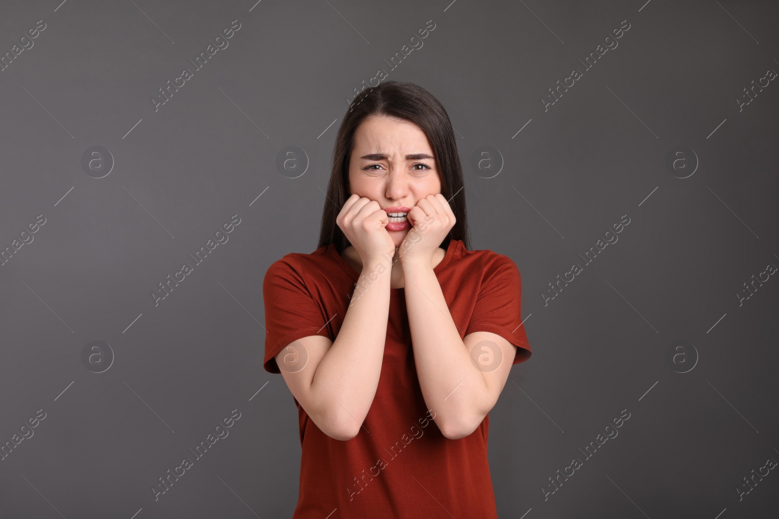 Photo of Portrait of emotional young woman on dark grey background. Personality concept