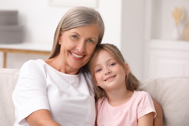 Photo of Happy grandmother with her granddaughter at home