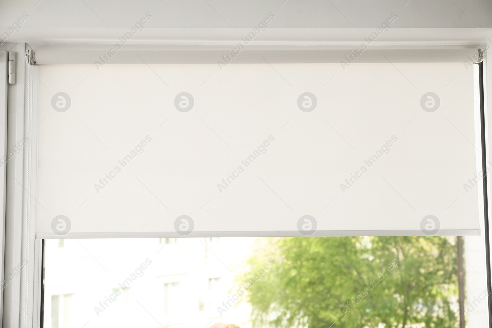 Photo of Window with modern roll blinds in room, closeup