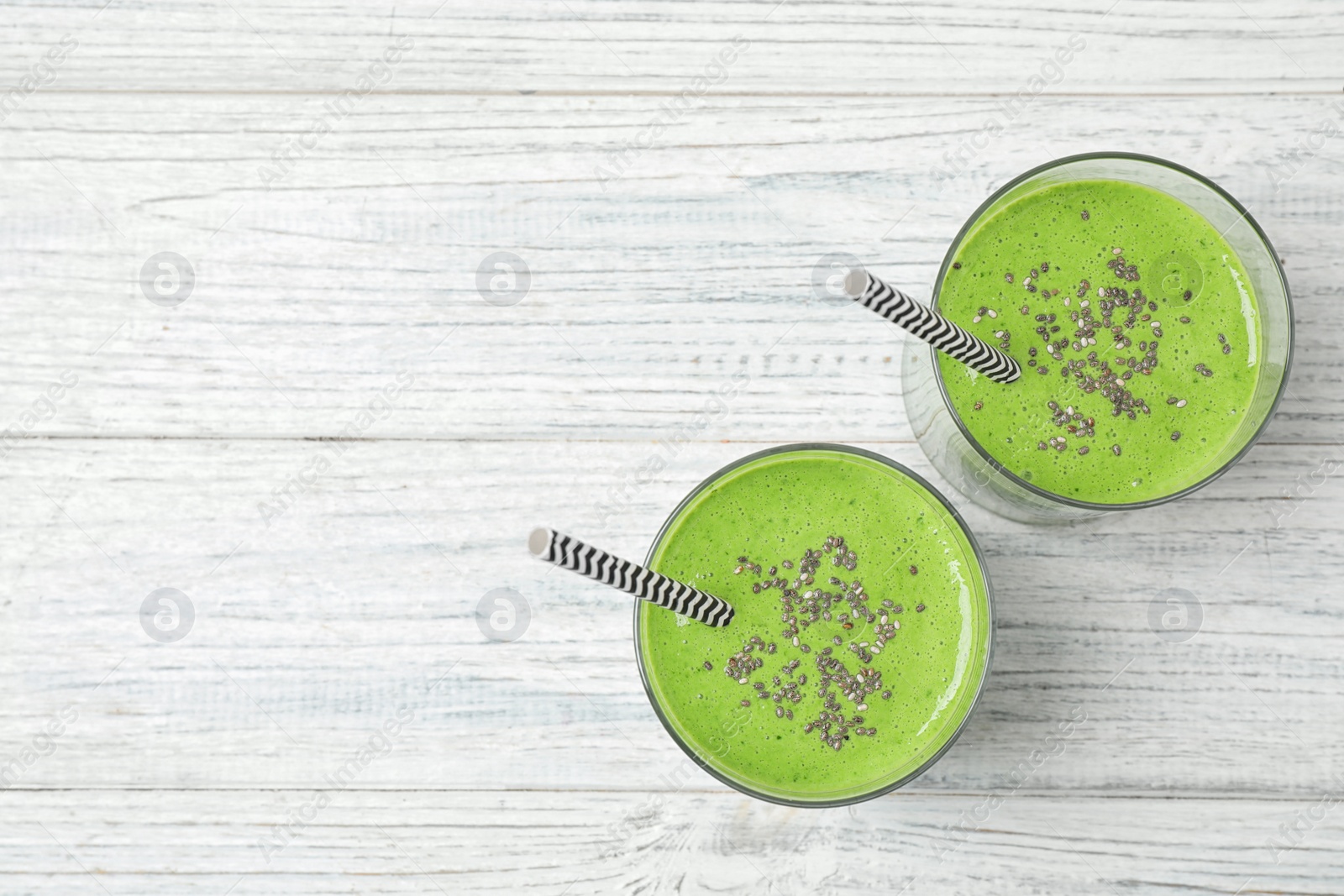 Photo of Tasty kale smoothie on white wooden table, flat lay. Space for text