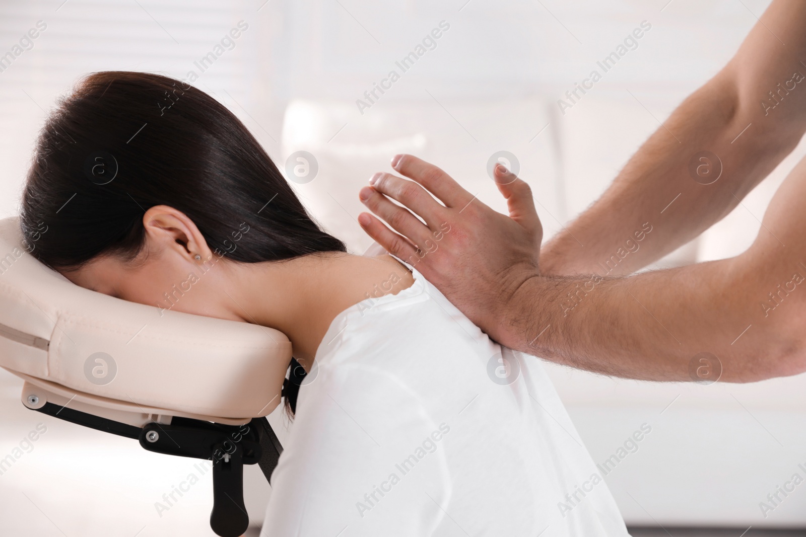 Photo of Woman receiving massage in modern chair indoors, closeup