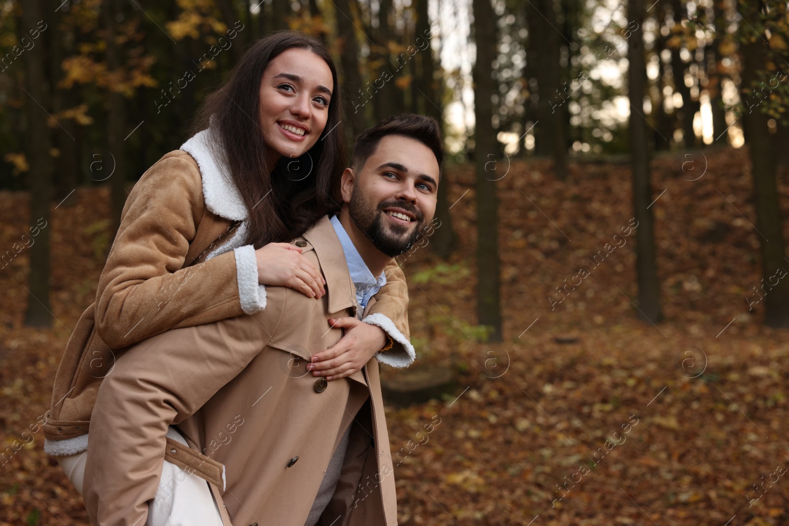 Photo of Romantic young couple spending time together in autumn park, space for text