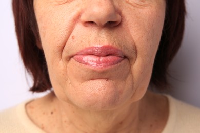 Closeup view of older woman on white background