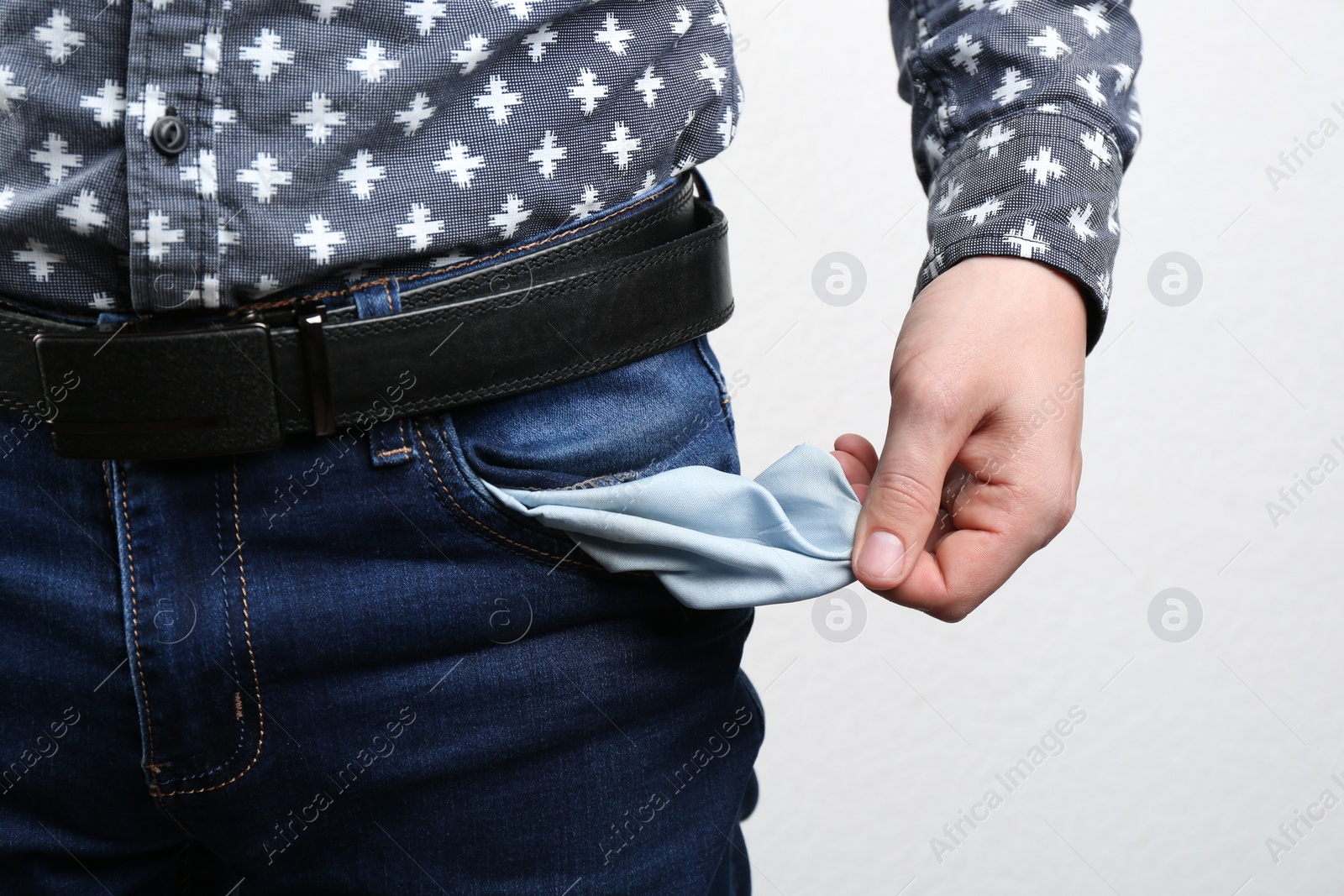 Man showing empty pocket on light background, closeup Photo of Man showing empty pocket on light background, closeup