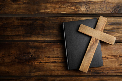 Photo of Christian cross and Bible on wooden background, top view with space for text. Religion concept