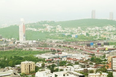 Picturesque view of cityscape with many buildings near mountain