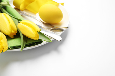 Festive Easter table setting with floral decor on white background, closeup