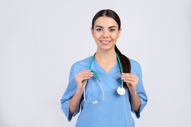 Photo of Portrait of medical assistant with stethoscope on light background