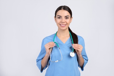 Portrait of medical assistant with stethoscope on light background