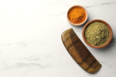 Photo of Comb, henna and turmeric powder on white marble table, flat lay. Space for text