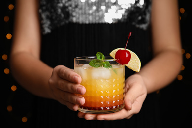 Photo of Woman with glass of Tequila Sunrise, closeup. Delicious alcoholic cocktail