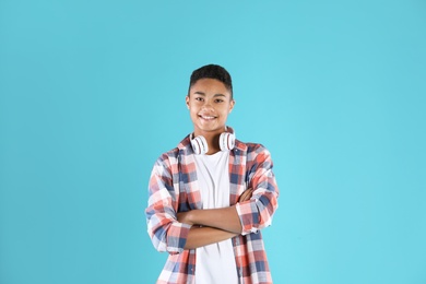 Photo of Portrait of African-American teenage boy with headphones on color background