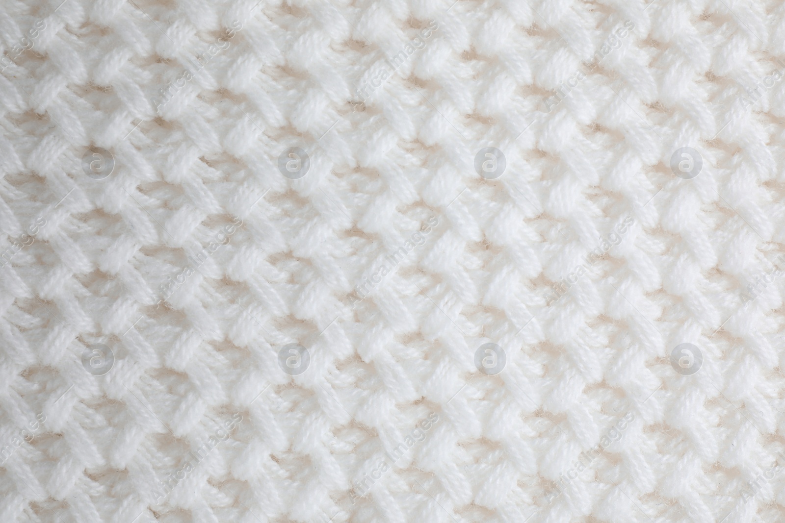 Photo of White knitted sweater as background, closeup view