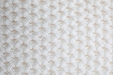 White knitted sweater as background, closeup view