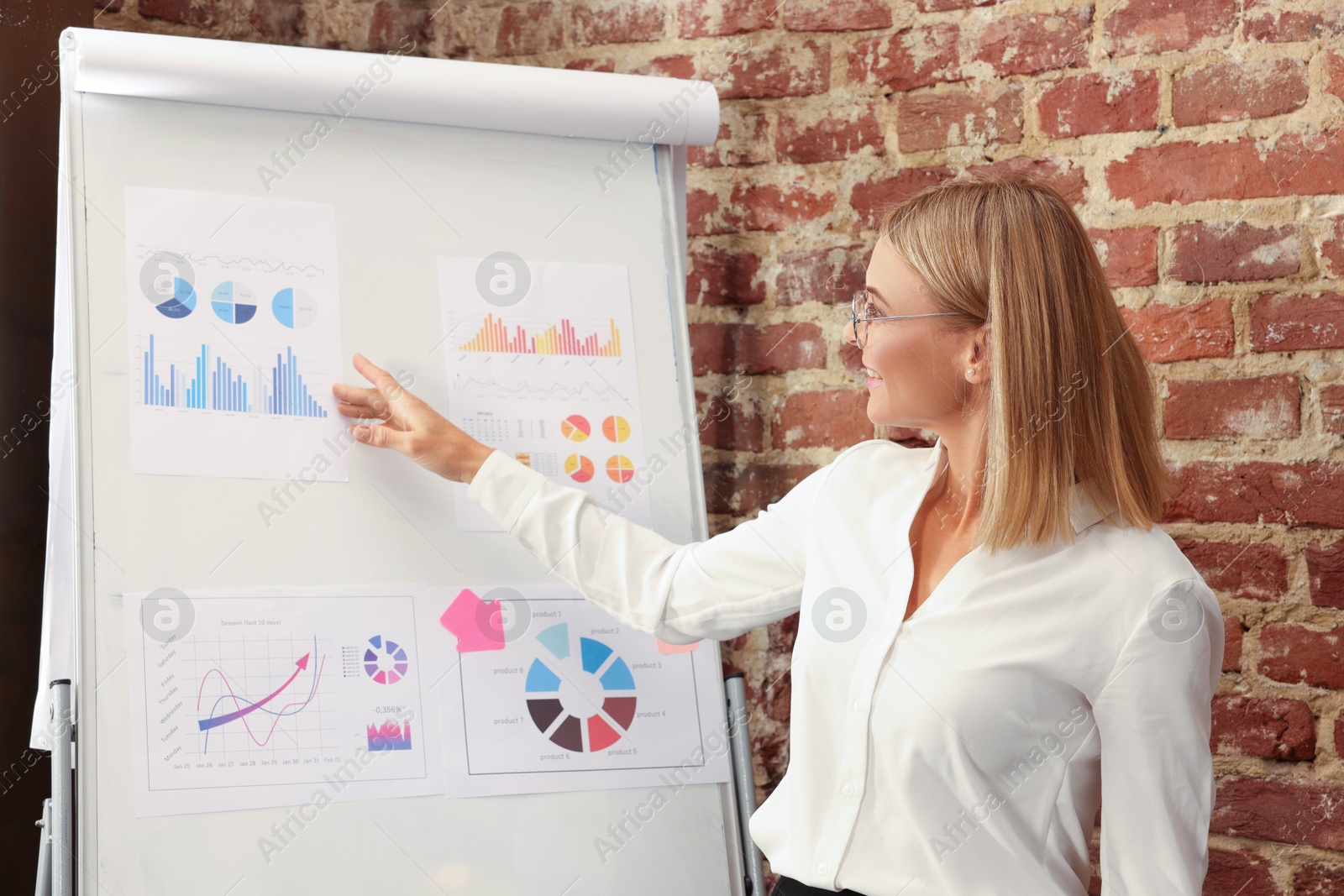 Photo of Businesswoman near flipchart board in office. Lady boss