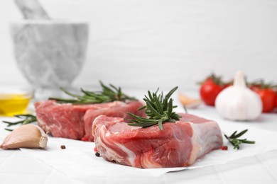 Fresh raw meat with rosemary on table, closeup