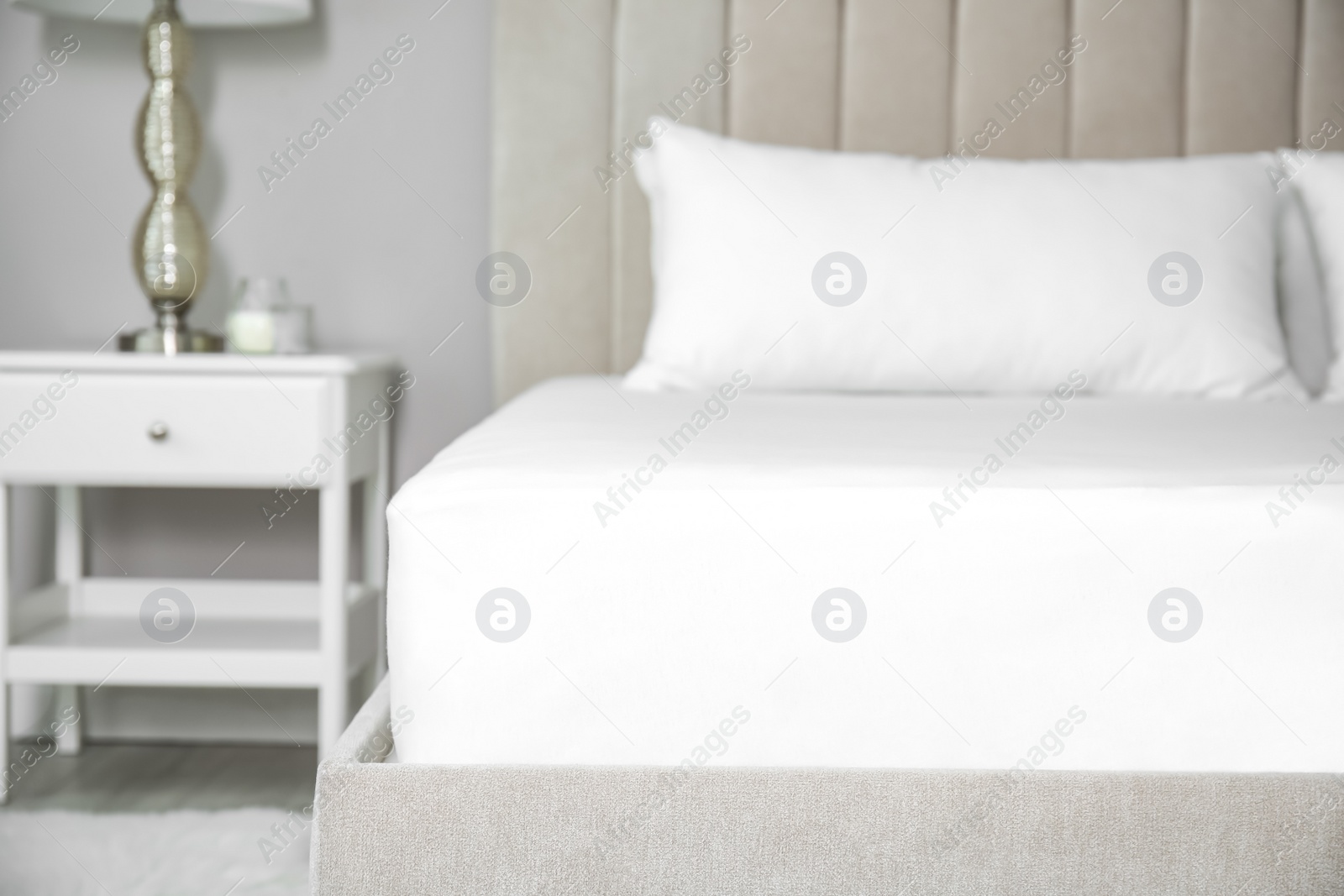 Photo of Mattress with white fitted sheet and pillows indoors