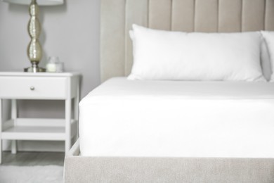 Photo of Mattress with white fitted sheet and pillows indoors