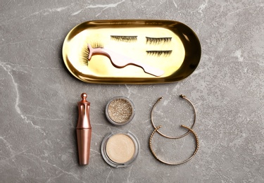 Flat lay composition with magnetic eyelashes and accessories on grey table