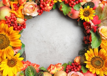 Photo of Beautiful autumnal wreath with flowers, berries and fruits on light grey background, closeup. Space for text