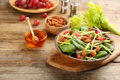 Photo of Delicious fresh celery salad on wooden table. Space for text