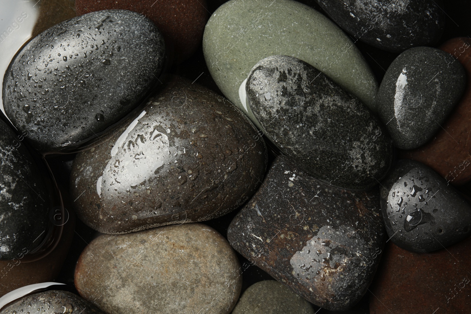 Photo of Pile of stones in water as background, top view. Zen lifestyle
